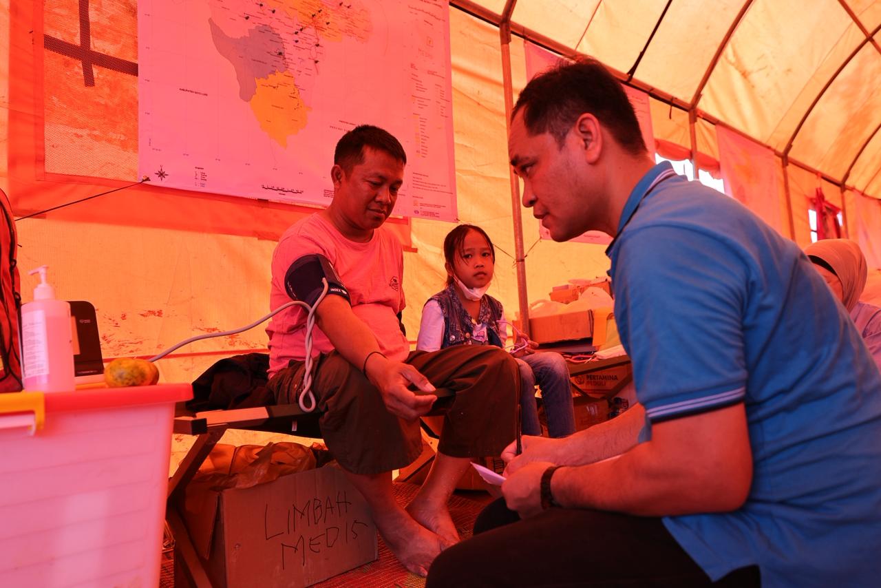 Salah satu warga bersama dengan putrinya memeriksa kesehatan di Posko Pertamina Peduli  'Melayani Sepenuh Hati', di Simpang Kantor Disdukcapil Aceh Tamiang, Aceh, Kamis, (1/1/2026) (Dok. Pertamina / Seputarsumatera.com)