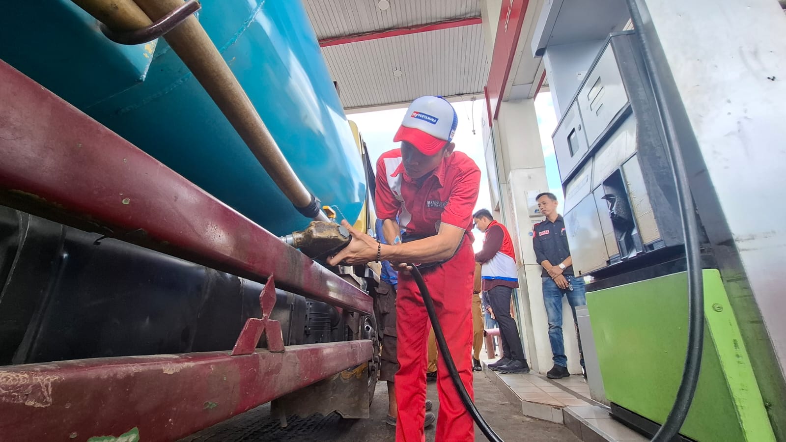 Petugas SPBU di Kayuagung Kabupaten OKI Sumsel saat mengisi BBM solar bersubsidi ke mobil truk yang sudah mengantre pada Selasa (14/7/2026) siang (Nefri Inge / Seputarsumatera.com)