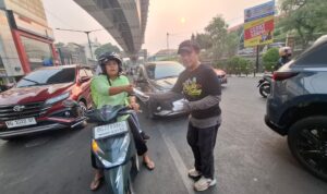 Mpit,.Ketua Yayasan Kawan Lamo Galo Sumsel saat membagikan masker ke pengendara sepeda motor (Dok. Humas Yayasan Kawan Lamo Galo Sumsel)